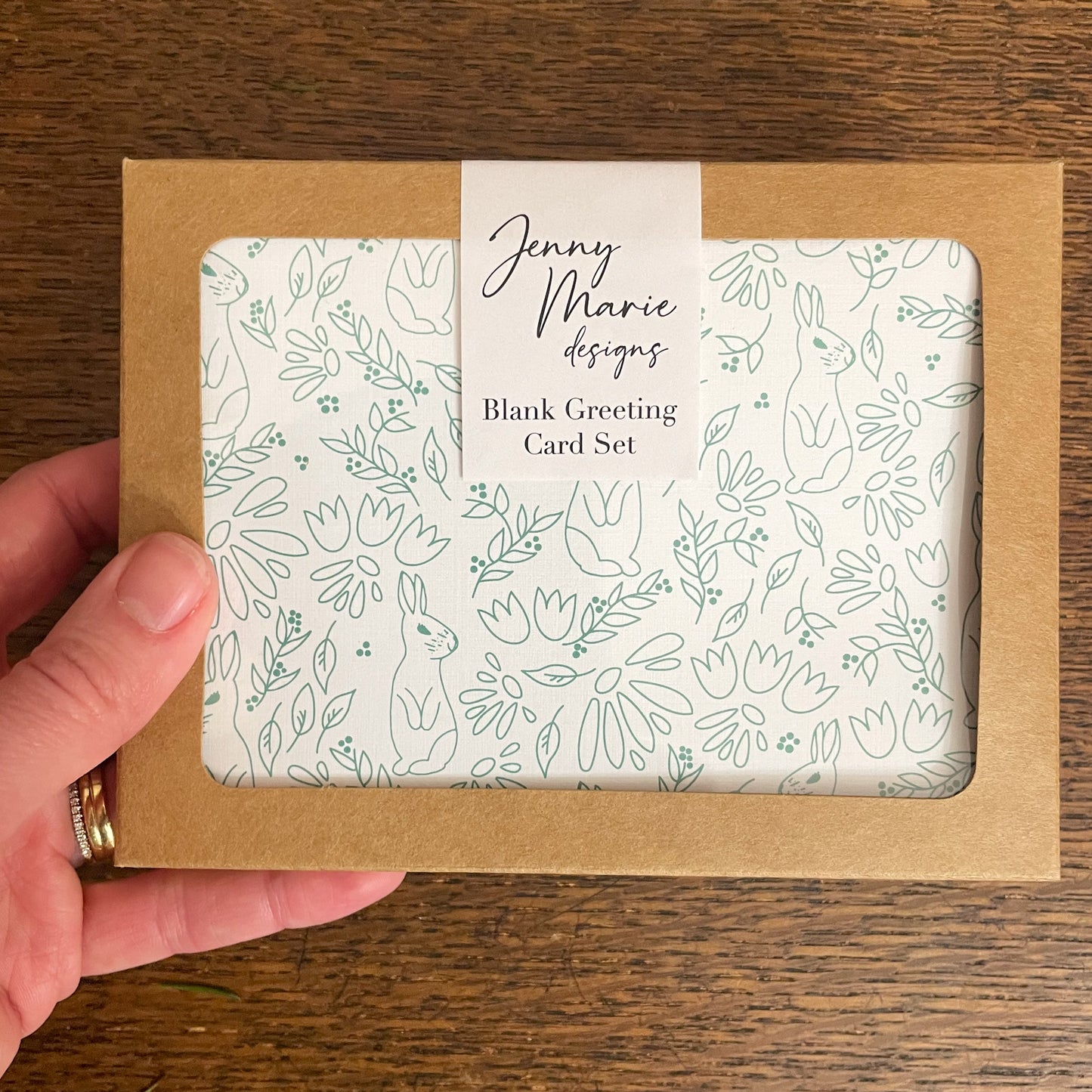 Photo of greeting card set inside of retail packaging being held in hand.